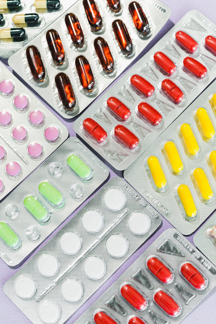 Close-up view of multiple blister packs with colorful pills and capsules arranged neatly.